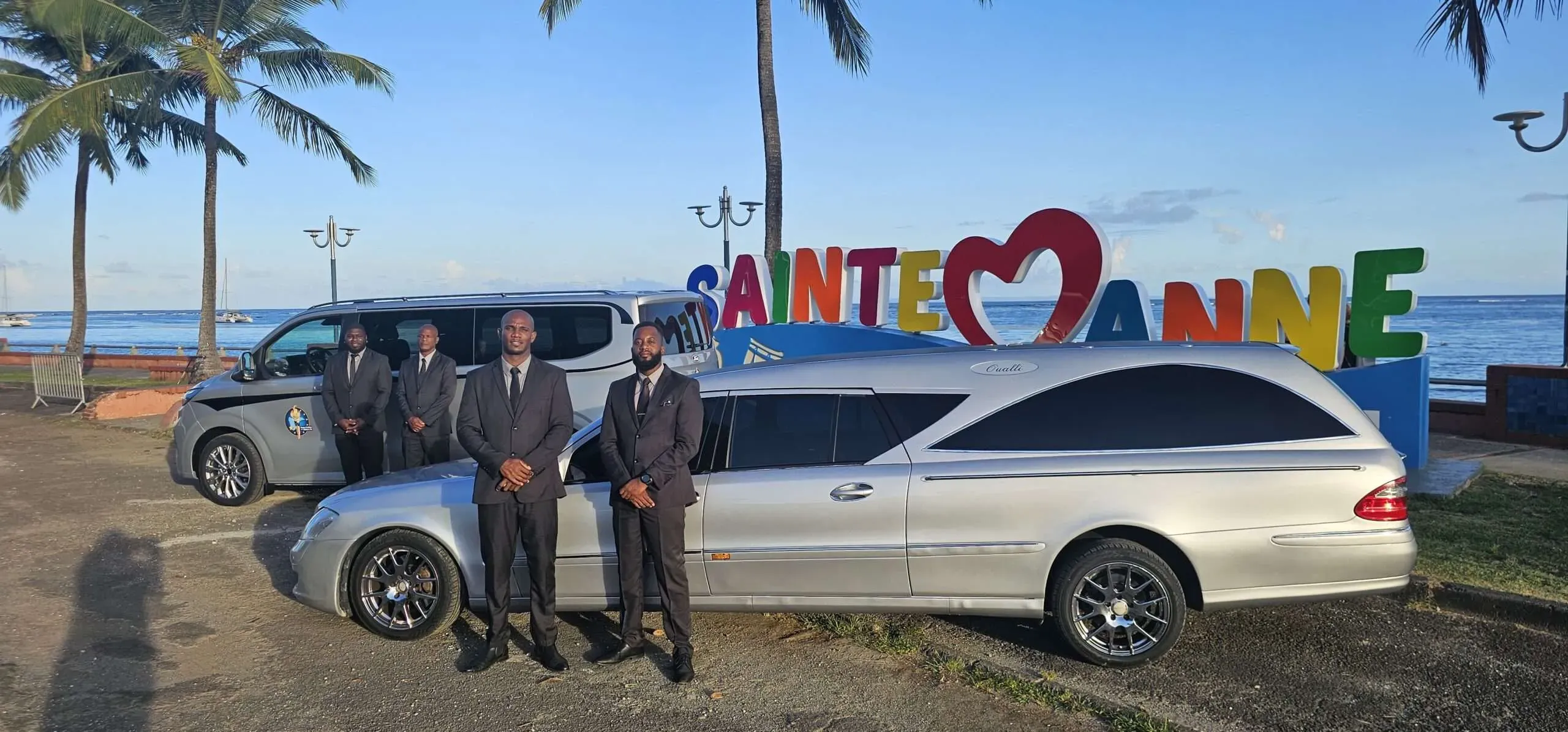 Porteurs et véhicules funéraires garés devant Sainte-Anne