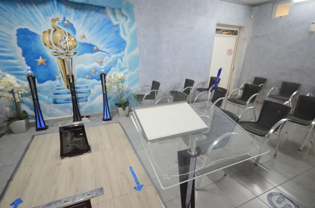 Salle de hommage avec pupitre transparent et sièges de recueillement